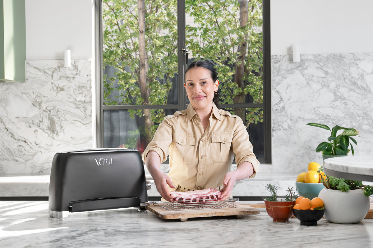 Preparing pork chops for cooking with the black VGrill vertical grill in a modern kitchen